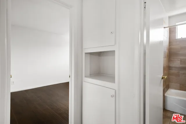 an empty room with wooden floor and window