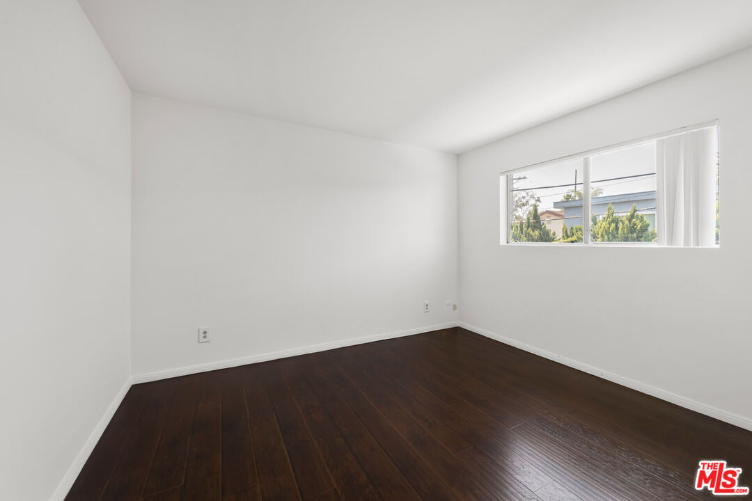 3355 South Canfield Avenue, Unit 11 Los Angeles, CA 90034 - Photo 13 of 23 an empty room with wooden floor and window