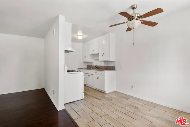 a kitchen with white cabinets and white appliances
