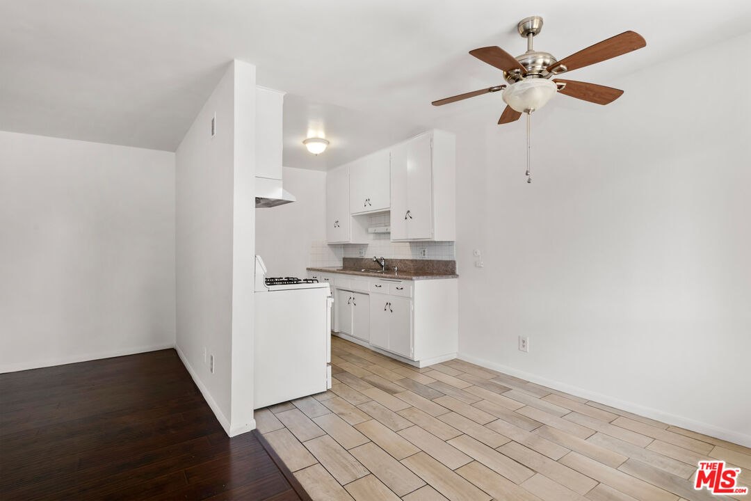 3355 South Canfield Avenue, Unit 11 Los Angeles, CA 90034 - Photo 3 of 23 a kitchen with white cabinets and white appliances