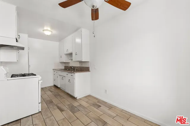a kitchen with white cabinets and white appliances