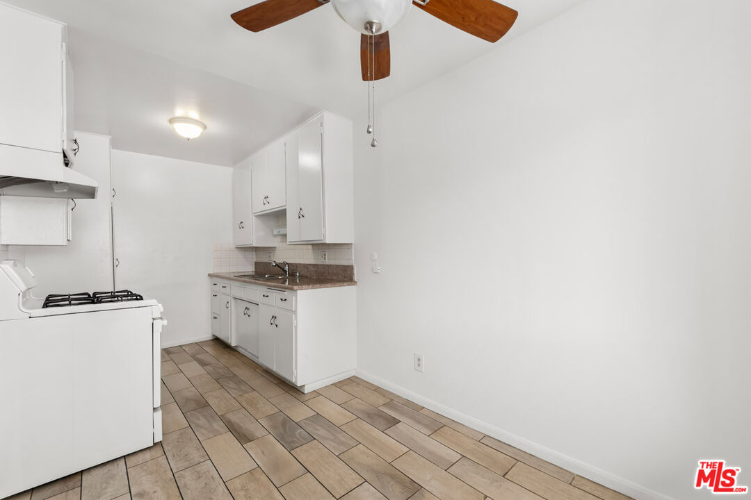 3355 South Canfield Avenue, Unit 11 Los Angeles, CA 90034 - Photo 4 of 23 a kitchen with white cabinets and white appliances