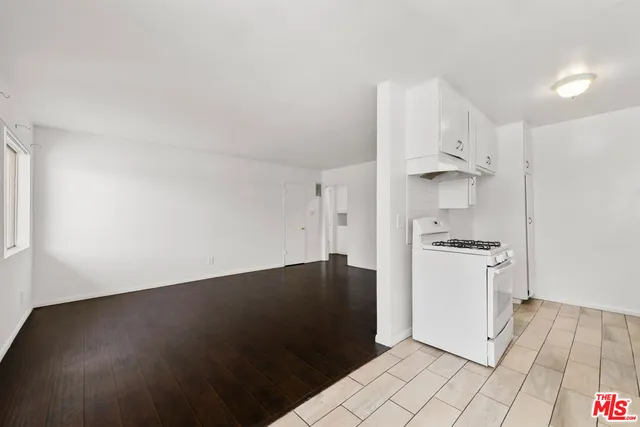 a kitchen with granite countertop white cabinets and refrigerator