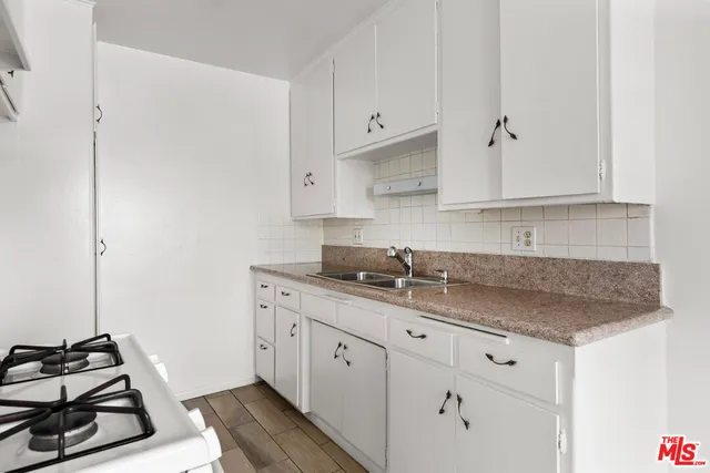 a kitchen with granite countertop white cabinets and white appliances