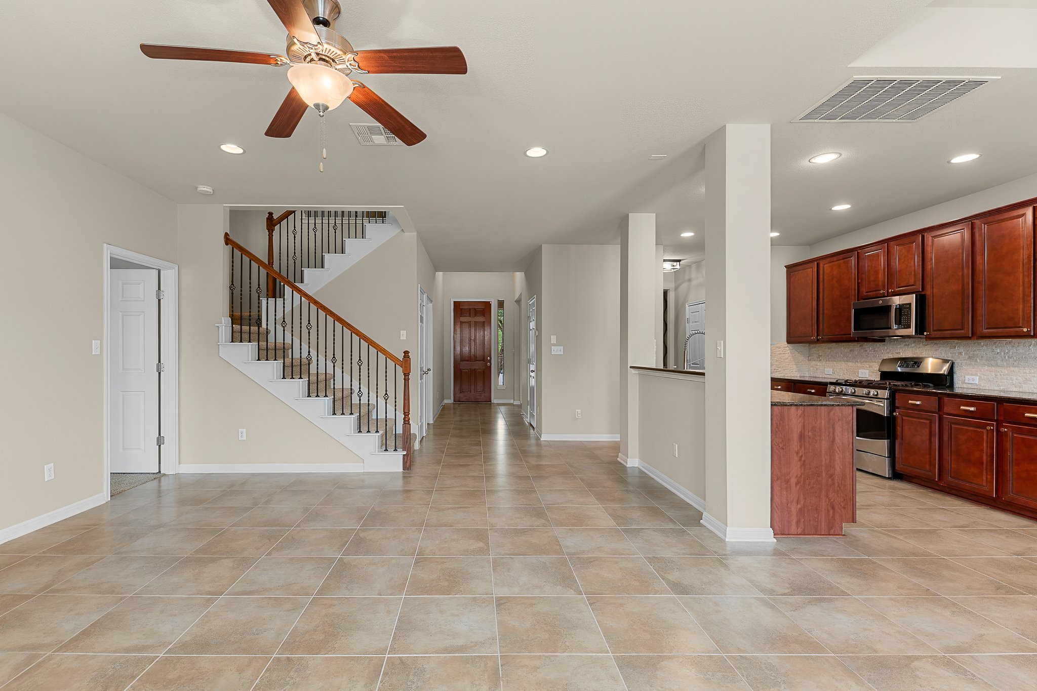 2813 Granite Hill Cove Leander, TX 78641 - Photo 14 of 39 Kitchen featuring stainless steel appliances, a ceiling fan, dark stone counters, recessed lighting, and tasteful backsplash