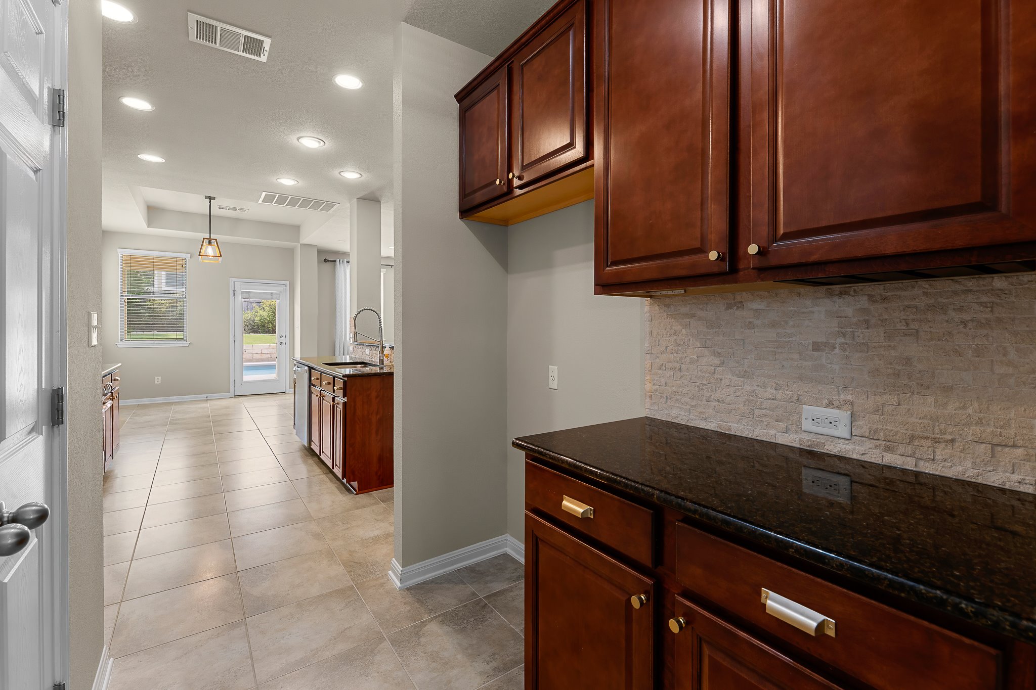 2813 Granite Hill Cove Leander, TX 78641 - Photo 20 of 39 Kitchen with recessed lighting, dark stone countertops, light tile patterned floors, backsplash, and dishwasher - freshly painted