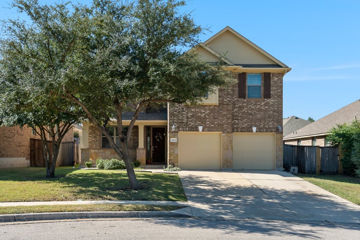 2813 Granite Hill Cove Leander, TX 78641 - Photo 2 of 35 a front view of a house with a garden and trees