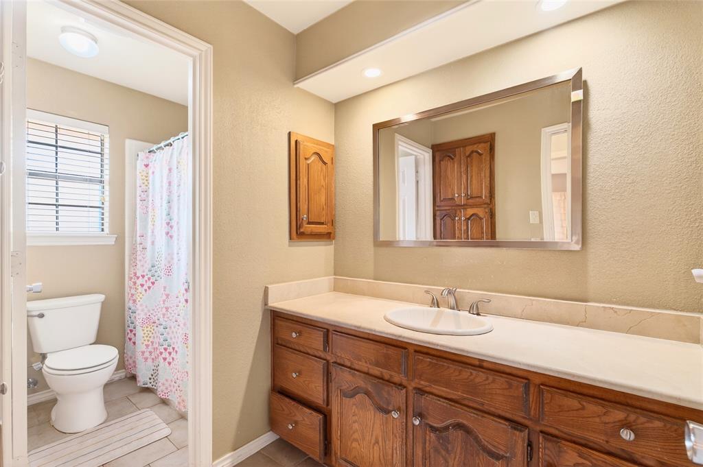 819 Lockhaven Lane Coppell, TX 75019 - Photo 26 of 33 A full secondary bath with a single vanity, tons of counters space, tub and shower combination, and natural light from the window.