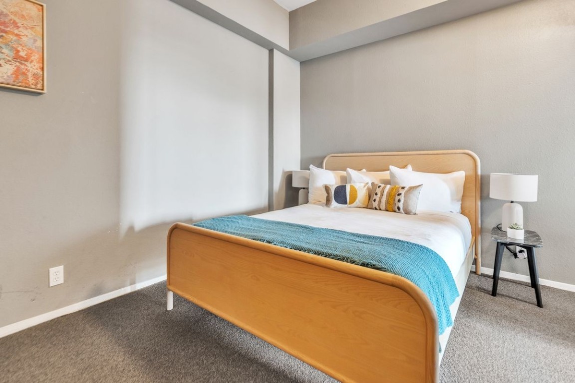 119 East 6th Street, Unit 702 Austin, TX 78701 - Photo 10 of 11 Carpeted bedroom featuring baseboards