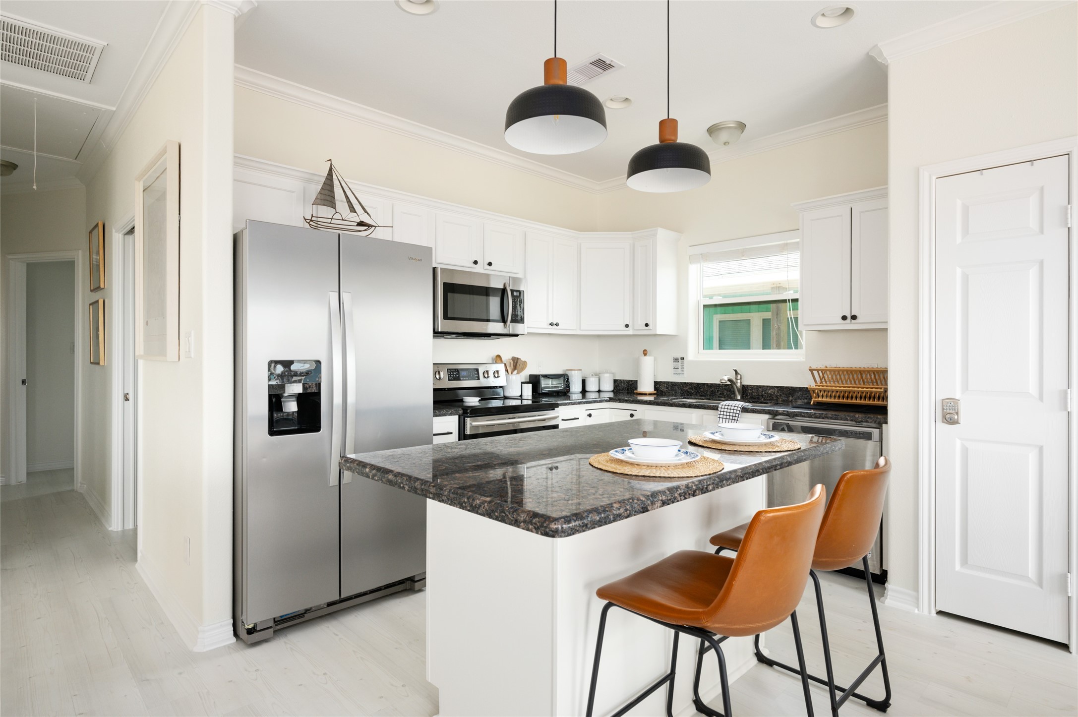 963 James Road Port Bolivar, TX 77650 - Photo 19 of 47 The kitchen boasts stainless steel appliances, granite countertops, and a spacious island currently seating two.