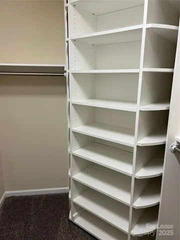 a view of walk in closet with empty racks