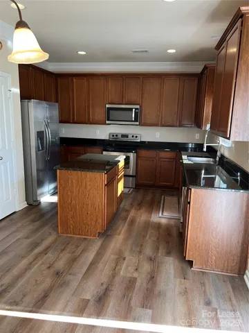 a kitchen with stainless steel appliances granite countertop a stove a sink and a refrigerator