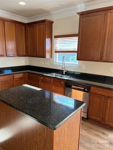 a kitchen with stainless steel appliances granite countertop a sink a stove a counter space and cabinets