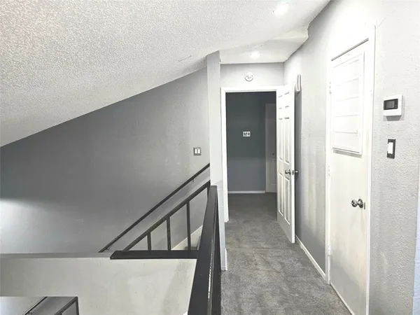 an empty room with chandelier fan and windows