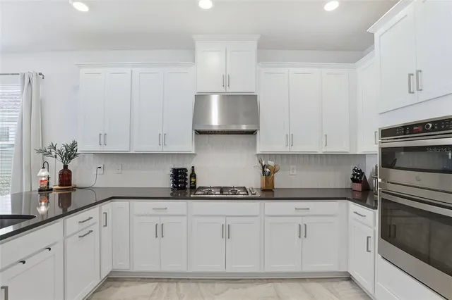 a kitchen with white cabinets and white appliances