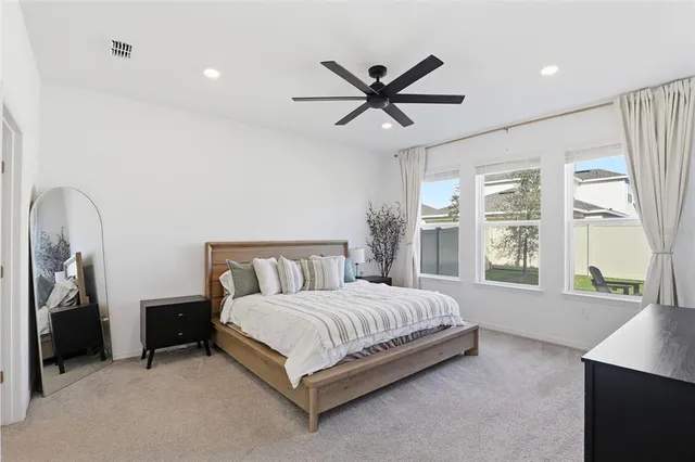 a bedroom with a bed a window and a chandelier
