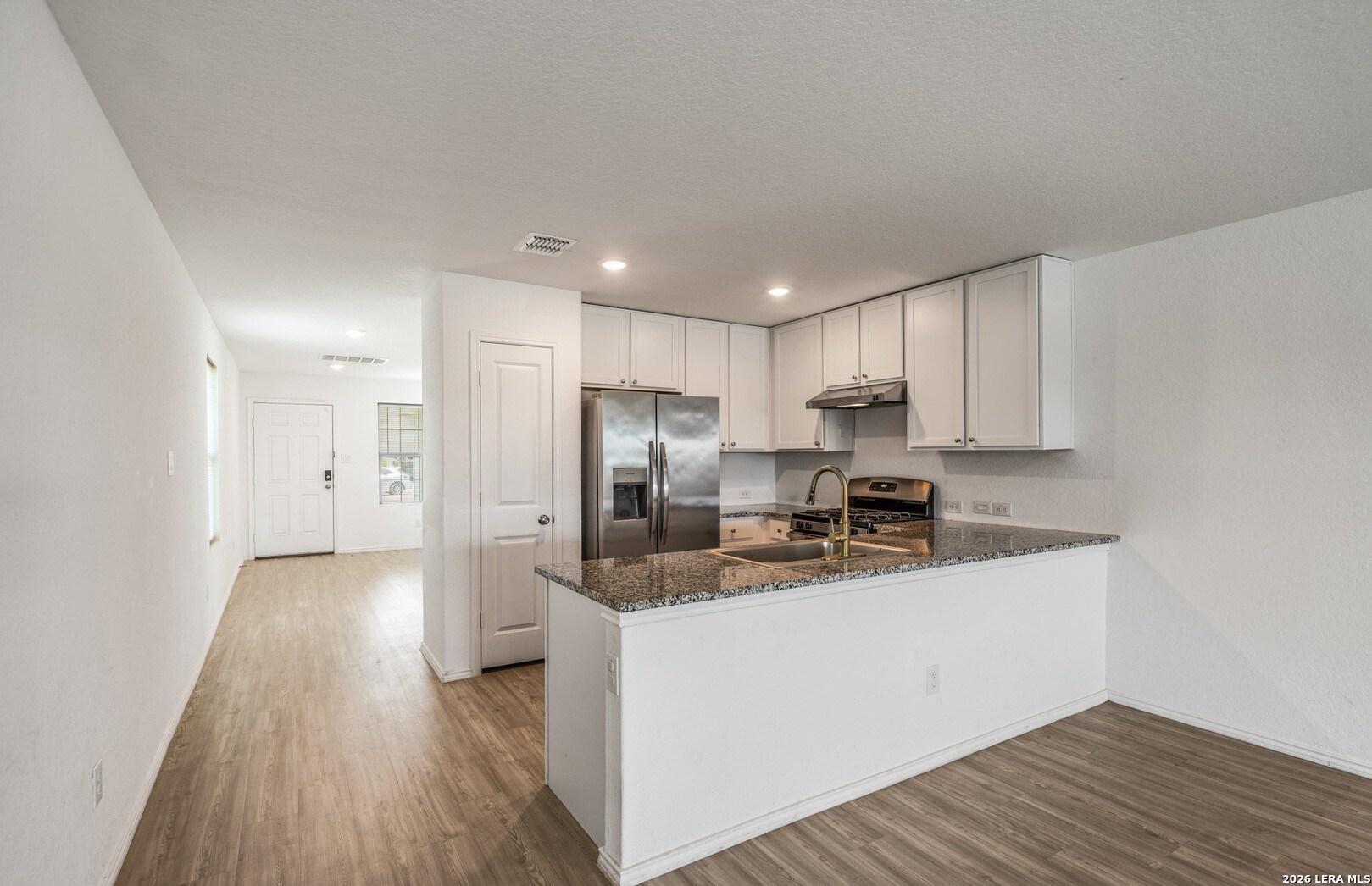 6566 Runaway Row Converse, TX 78109 - Photo 10 of 27 a kitchen with stainless steel appliances granite countertop a sink a stove a refrigerator and cabinets