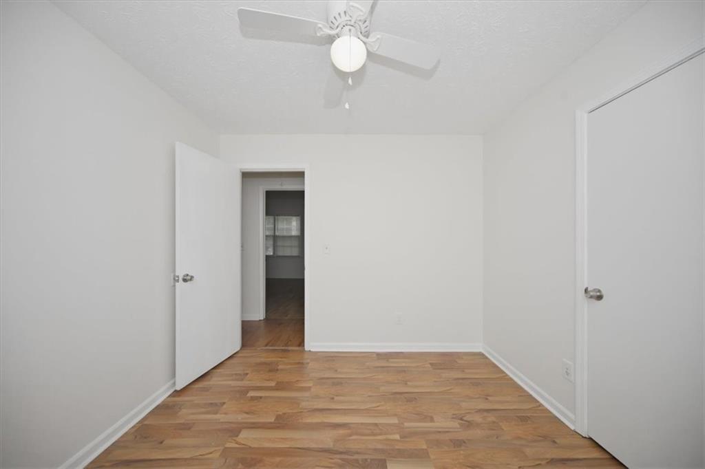 1496 Cherry Hill Road Southwest Conyers, GA 30094 - Photo 22 of 32 a view of an empty room with wooden floor and fan