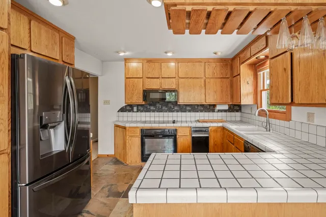 a kitchen with stainless steel appliances granite countertop a refrigerator and a sink