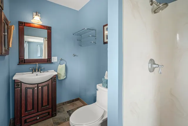 a bathroom with a sink a toilet and mirror