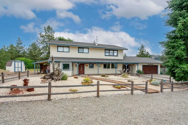 a white house that has a tree in front of it