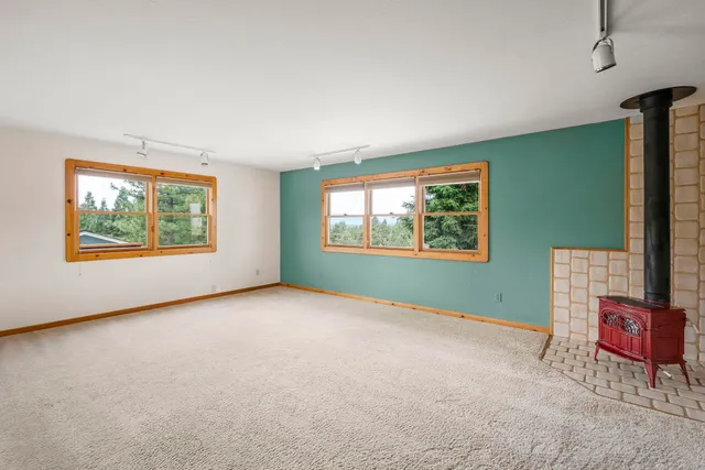an empty room with windows and ceiling fan