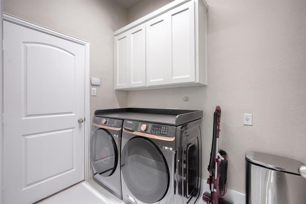 2246 Longview Road Irving, TX 75063 - Photo 18 of 40 Laundry area featuring overhead white shaker-style cabinetry, light neutral wall paint, and a solid white door with an arched panel design