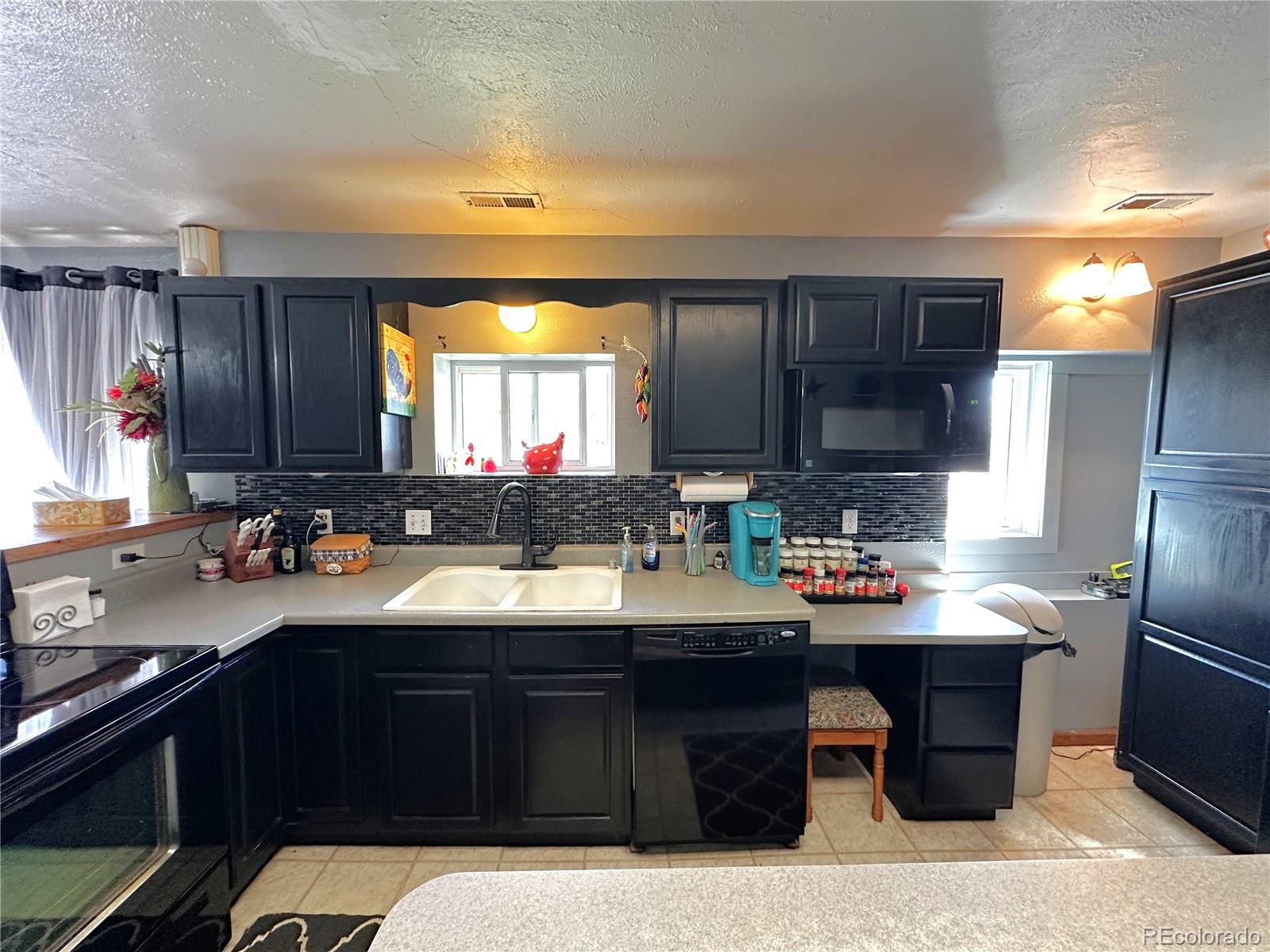 329 6th Street Hugo, CO 80821 - Photo 10 of 50 a kitchen with a sink a stove and cabinets