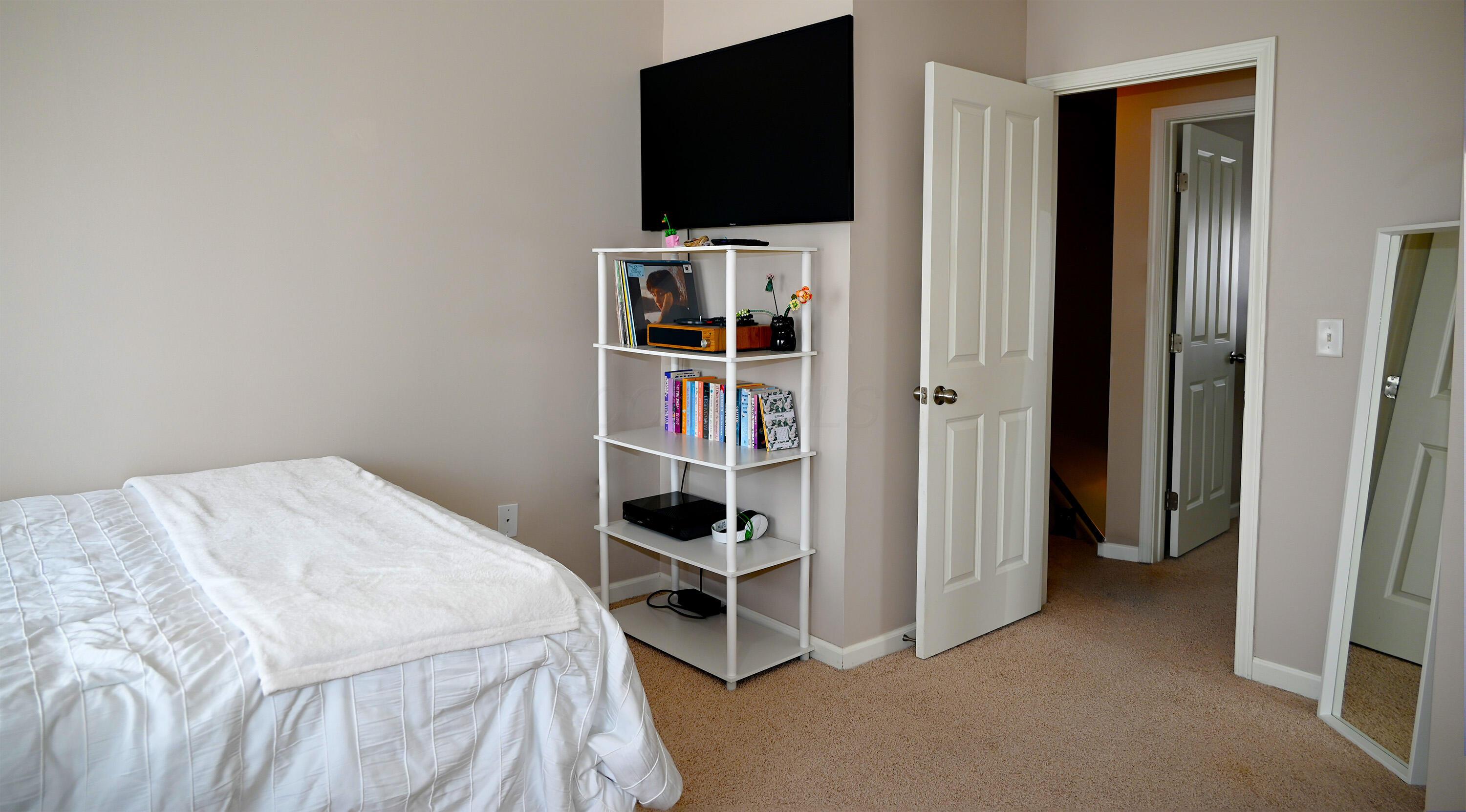 8289 Bruntsfield Road Columbus, OH 43235 - Photo 21 of 36 Comfortable secondary bedroom offering ample natural light, spacious closet storage, and a flexible layout to accommodate guests, remote work, or everyday living.