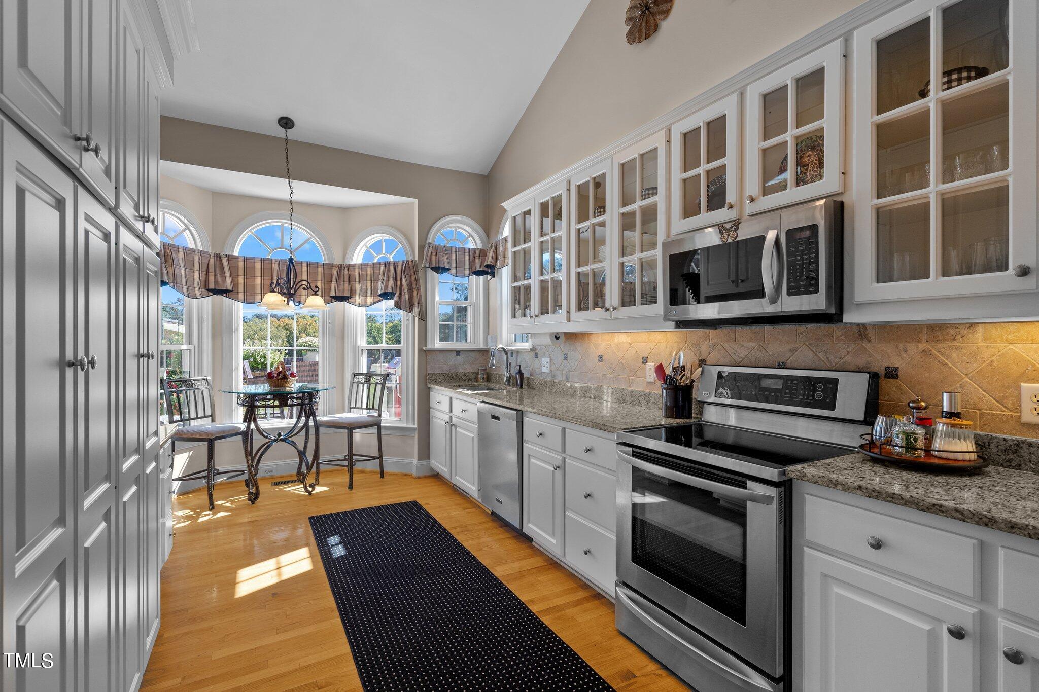 10125 Goodview Court Raleigh, NC 27613 - Photo 19 of 45 a kitchen with stainless steel appliances granite countertop a stove and cabinets