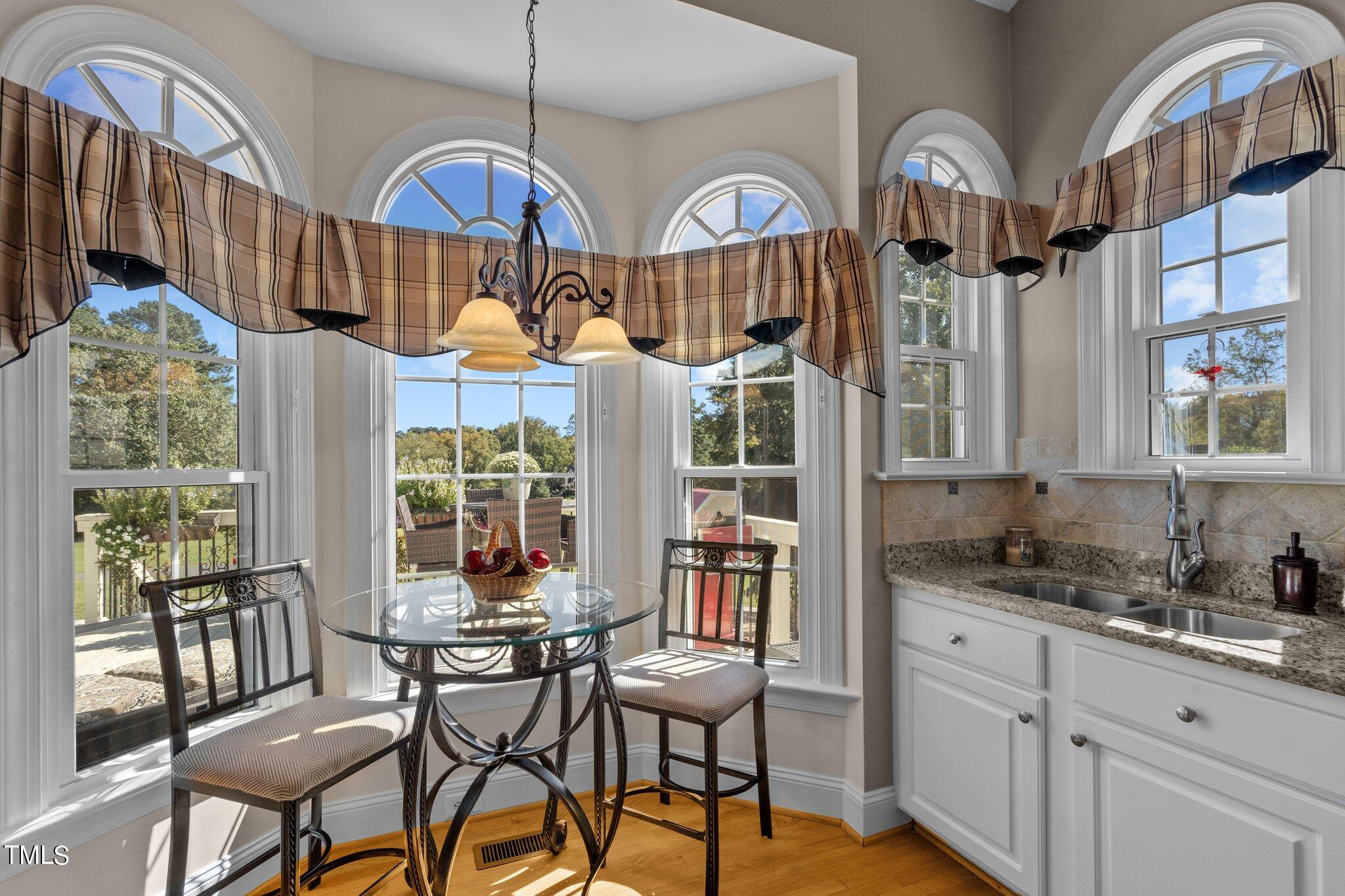 10125 Goodview Court Raleigh, NC 27613 - Photo 20 of 45 a view of a kitchen with granite countertop a table chairs stove and cabinets