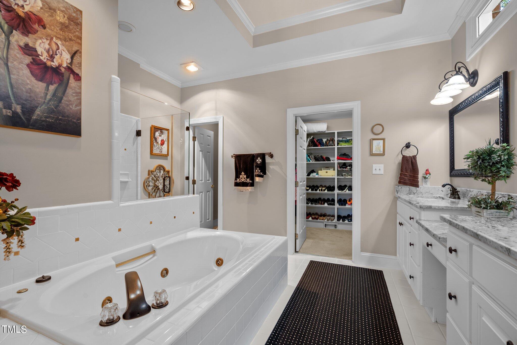 10125 Goodview Court Raleigh, NC 27613 - Photo 25 of 45 a bathroom with a tub a sink and a large mirror