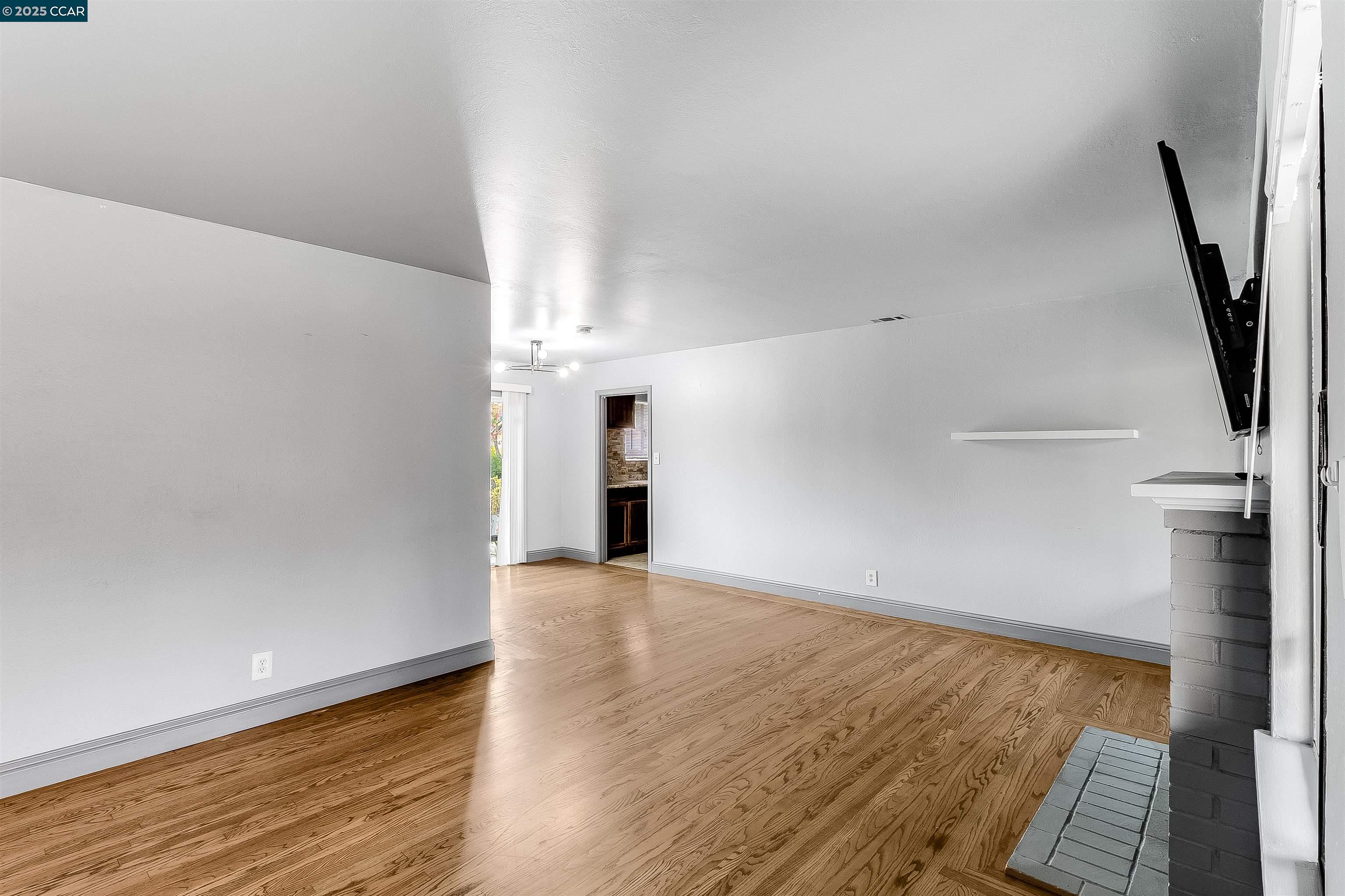 1216 Lincoln Street Fairfield, CA 94533 - Photo 14 of 28 a view of an empty room with wooden floor and a window