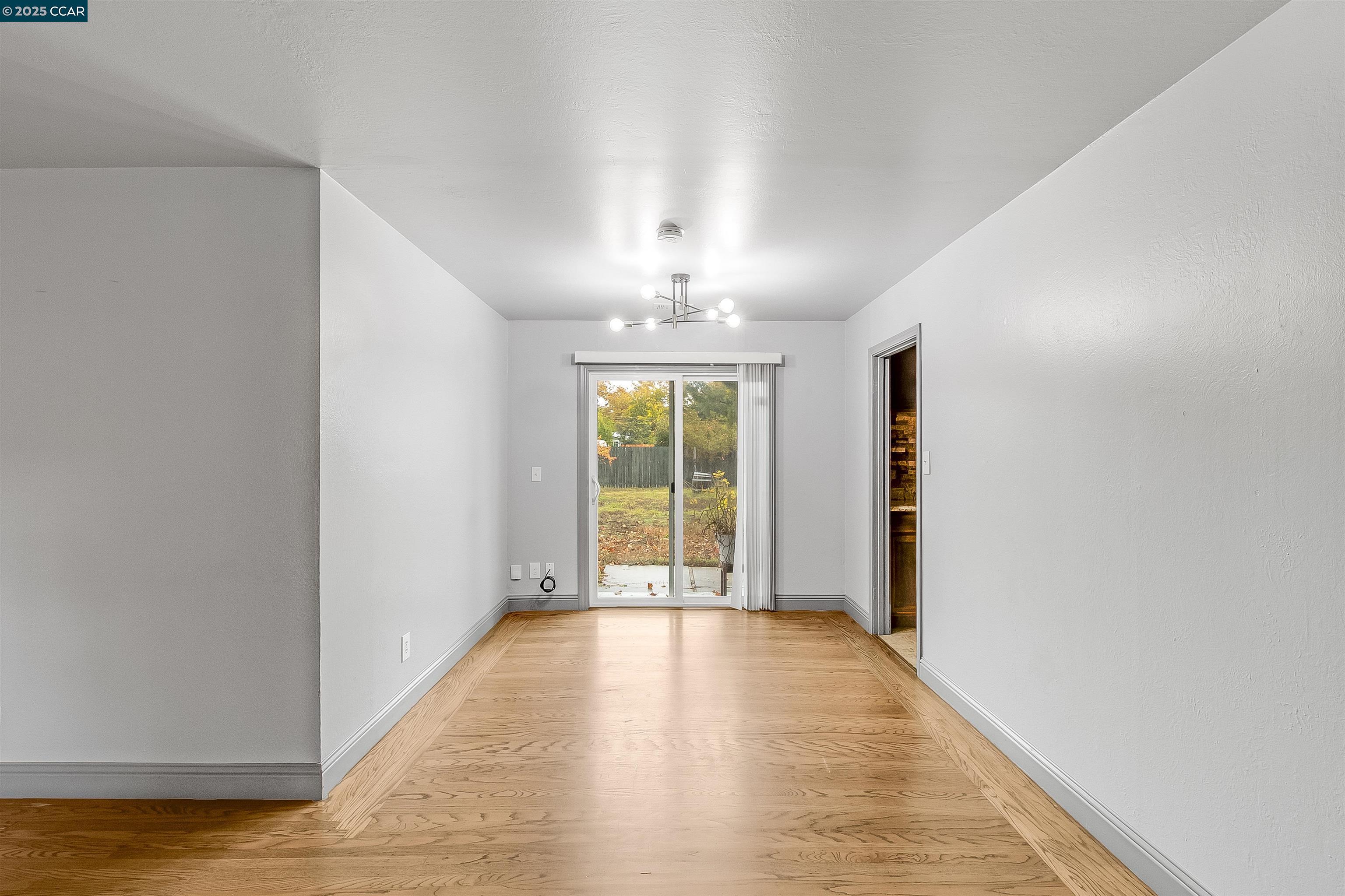 1216 Lincoln Street Fairfield, CA 94533 - Photo 15 of 28 a view of an empty room with window and wooden floor