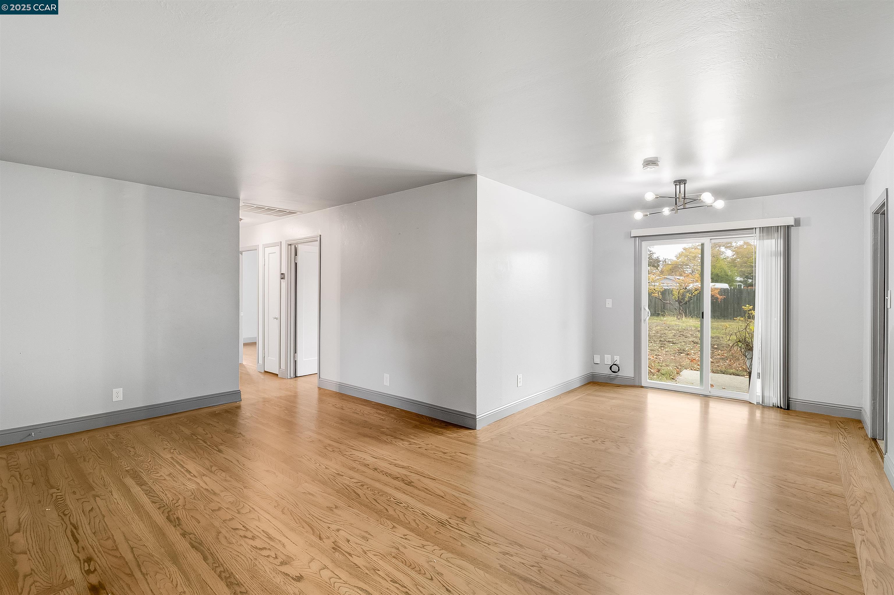 1216 Lincoln Street Fairfield, CA 94533 - Photo 6 of 28 a view of an empty room with glass door and wooden floor