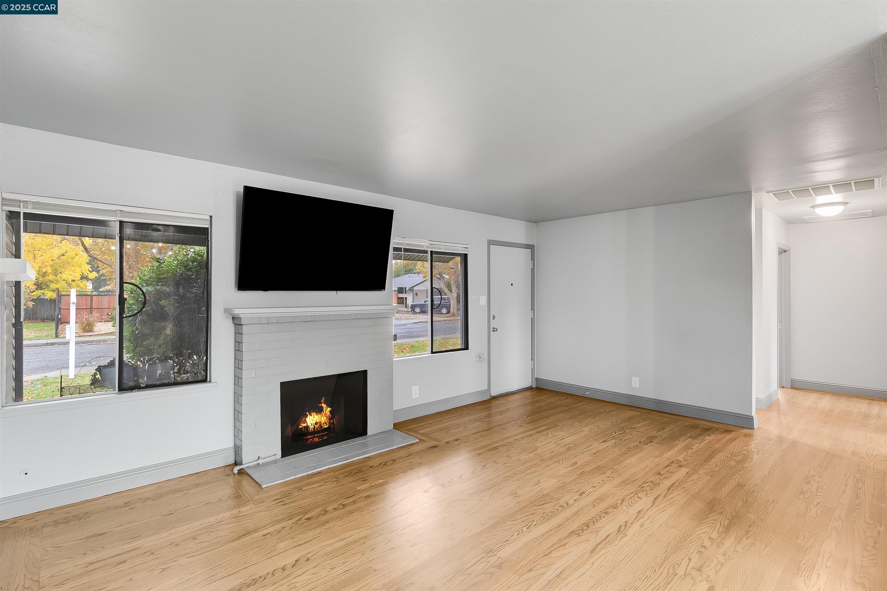 1216 Lincoln Street Fairfield, CA 94533 - Photo 7 of 28 a view of empty room with wooden floor and fireplace