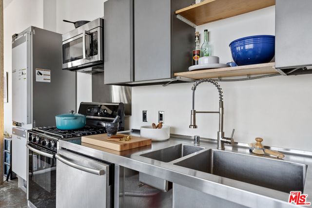 a kitchen with stainless steel appliances a sink a stove and cabinets