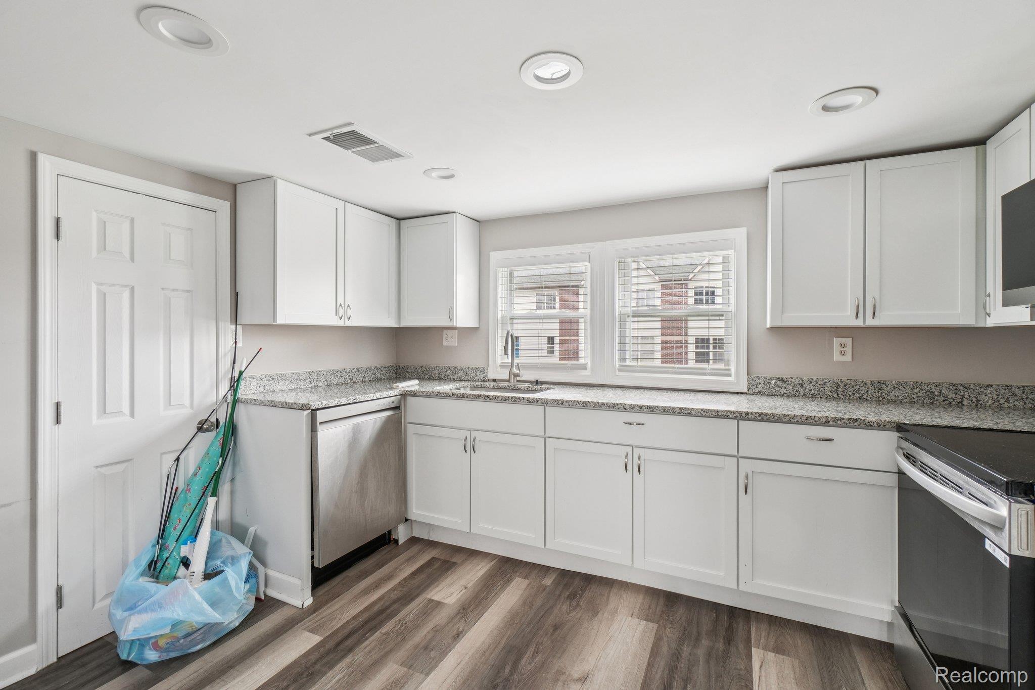 3822 Wabash Street Detroit, MI 48208 - Photo 9 of 17 Kitchen with white cabinetry, stainless steel appliances, dark wood-type flooring, light stone countertops, and recessed lighting