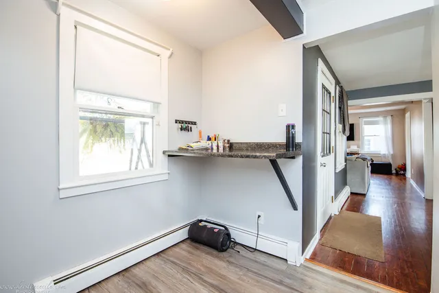 a view of a hallway with wooden floor and a window