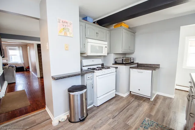 a kitchen with granite countertop a sink cabinets and wooden floor