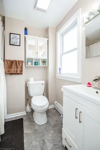 a bathroom with a toilet sink and window