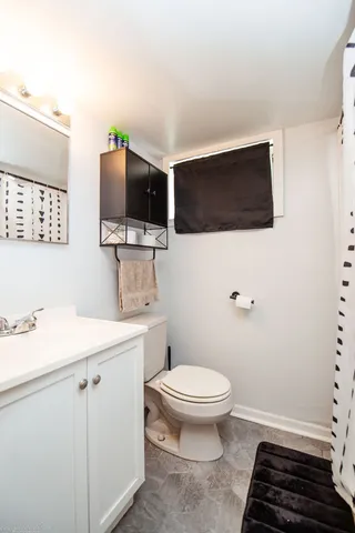 a bathroom with a toilet a sink and mirror