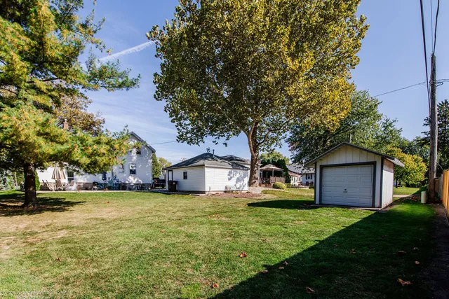 a view of a house with a big yard and large tree