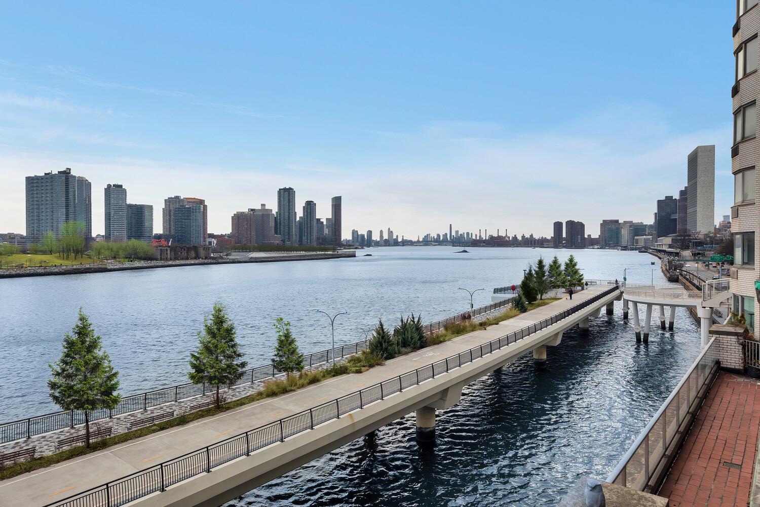 45 Sutton Place South, Unit 3FG Manhattan, NY 10022 - Photo 2 of 28 a view of a lake with tall buildings in the background