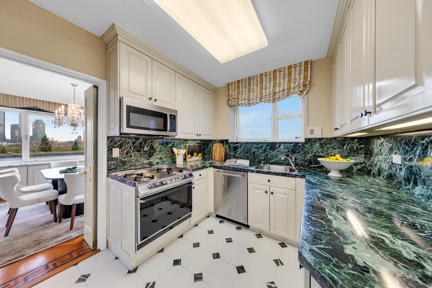 45 Sutton Place South, Unit 3FG Manhattan, NY 10022 - Photo 4 of 28 a kitchen with stainless steel appliances a stove a sink and a microwave