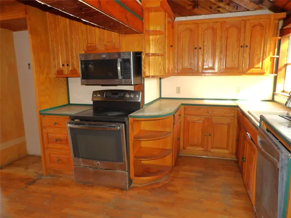 a kitchen with stainless steel appliances a stove a microwave and a sink