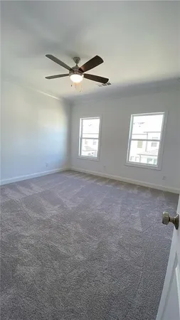 an empty room with windows and fan