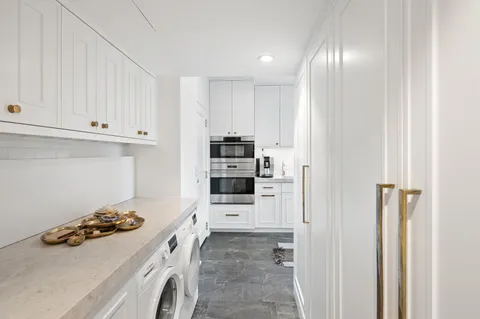 a kitchen with white cabinets and appliances