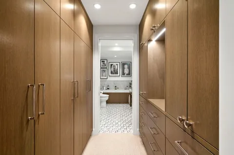 a bathroom with a glass door shower a sink and a toilet