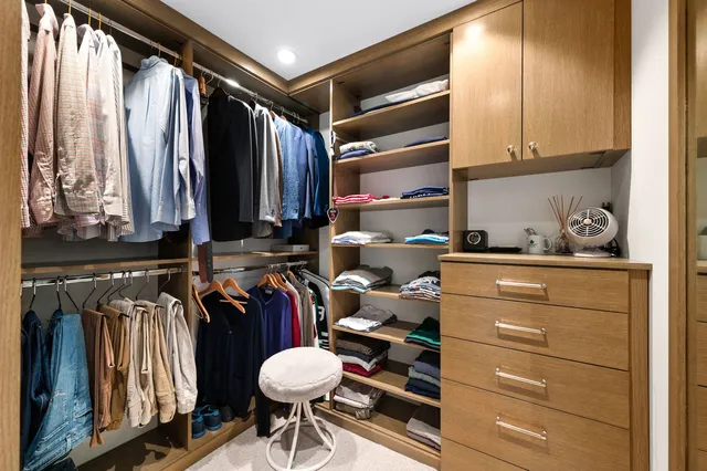 a view of walk in closet with clothes and shoes